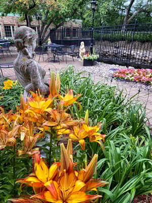 Beautiful garden with orange lilies and a sculpture