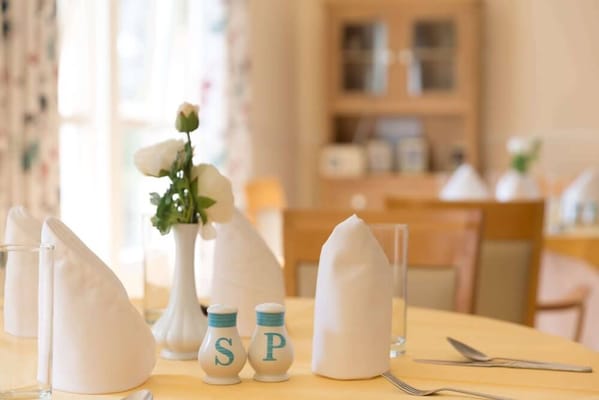 Dining table set up with napkins and flowers