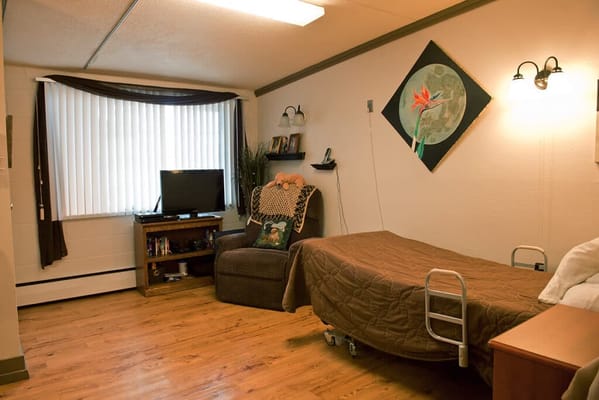 Cozy resident room with a bed and chair