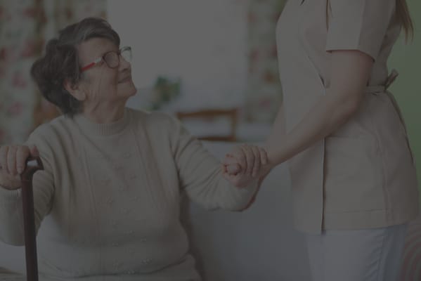 A caregiver holding hands with a senior resident