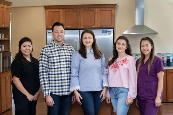 Staff members posing in a bright kitchen area