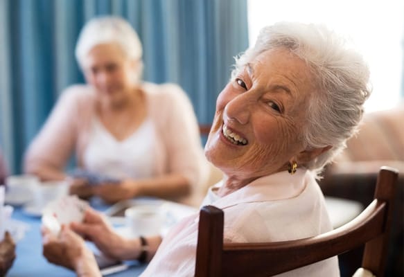 Residents enjoying a card game in a community room
