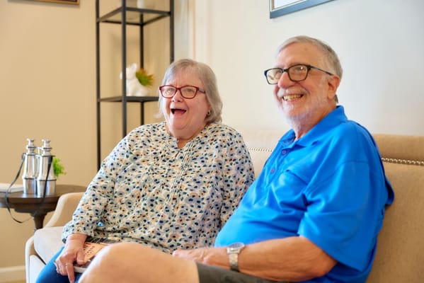 Residents sitting and smiling in a cozy common area