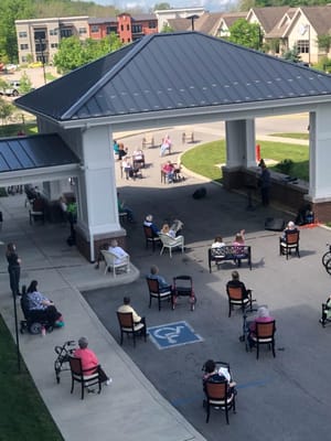 Residents enjoying an outdoor concert under a covered entrance