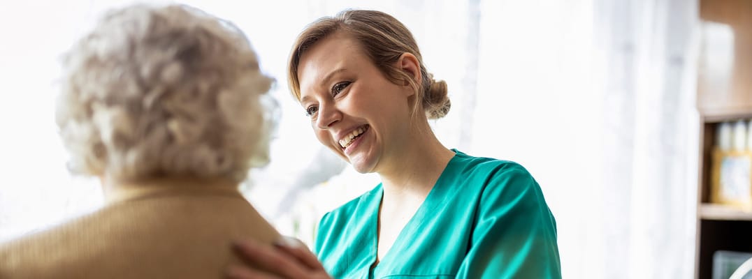 Caregiver smiling with a resident