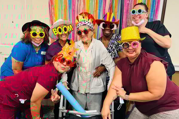 Residents and staff celebrating with fun hats and props