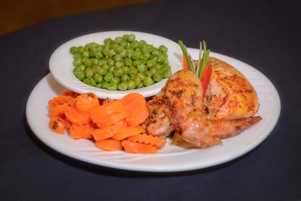 Plate of roasted chicken with vegetables
