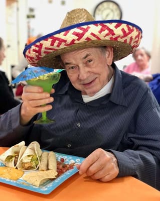 Resident enjoying a festive meal with a drink