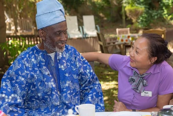 A resident and staff member enjoying a meal outdoors