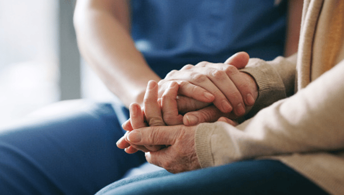 Two hands holding in a supportive gesture