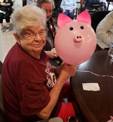 Elderly resident enjoying a balloon activity with a group