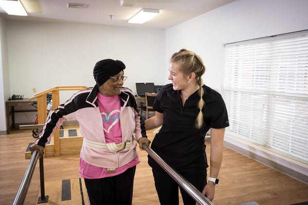 Therapist assisting a resident in an interior space
