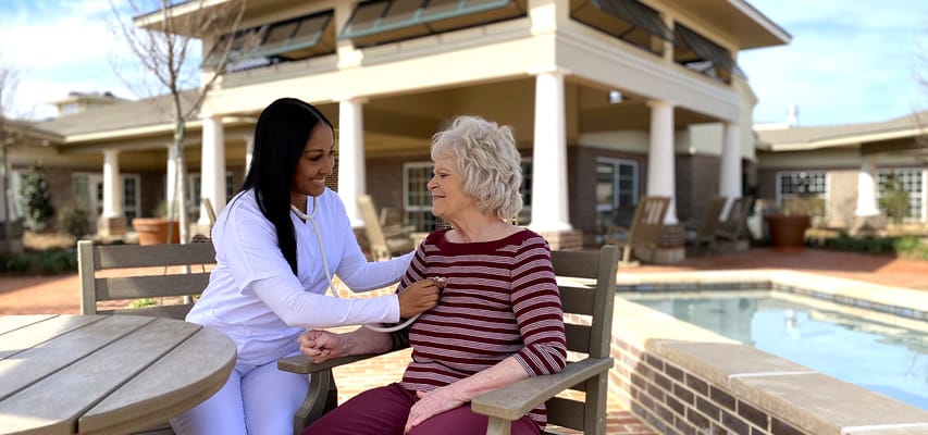 Caregiver interacting with resident in an outdoor setting