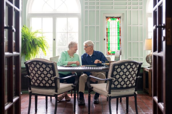 Two residents enjoying a game together in a cozy common area