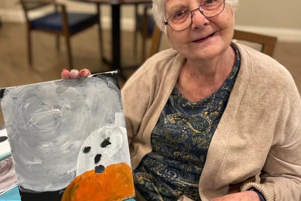 A resident proudly showing their painting