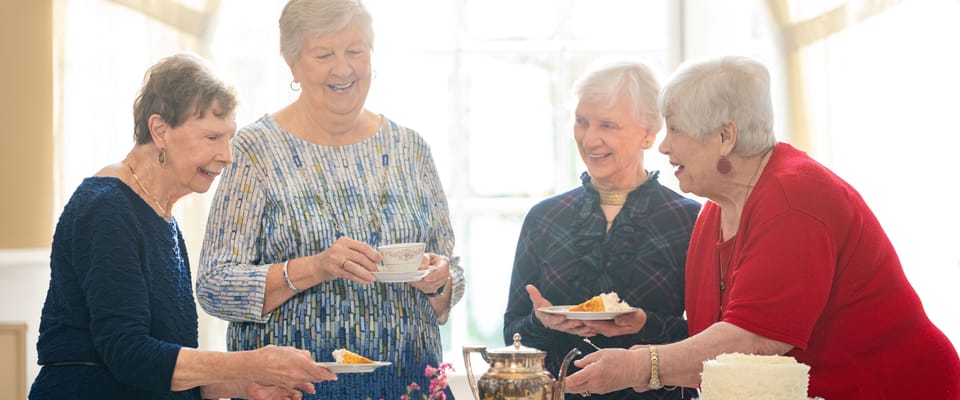 Residents enjoying dessert and conversation in a sunny room