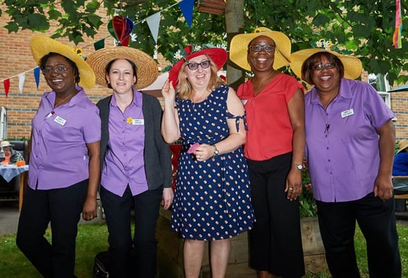 Staff members posing with hats at a garden event