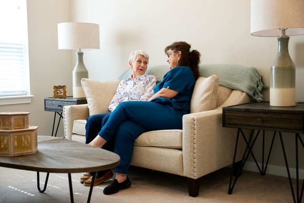 Resident and caregiver engaging in conversation on a couch