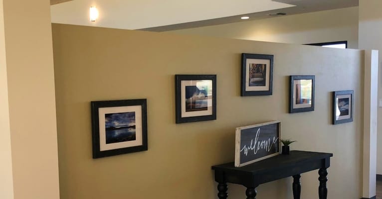 Interior view of a decorated hallway with frames and a sign