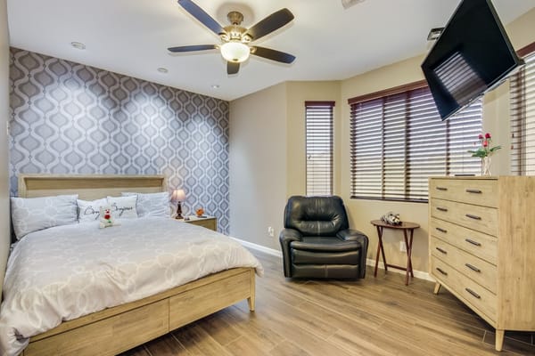 Cozy bedroom with a bed, armchair, and dresser