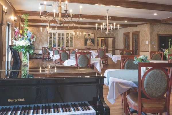 Elegant dining room setup with chandelier and piano