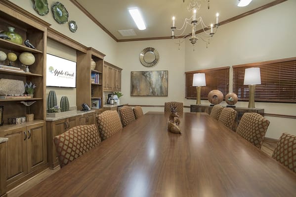 A well-lit meeting room with a large wooden table
