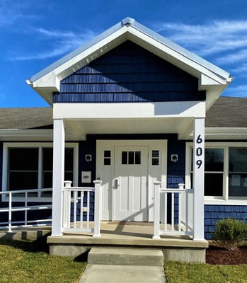 Front entrance of a blue-shingled facility building
