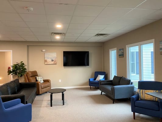 Bright common area with seating and a TV