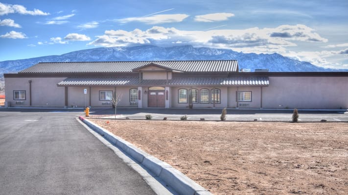 Exterior view of a senior living facility with mountains