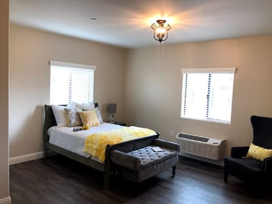 Interior of a resident's private room with bed and decor