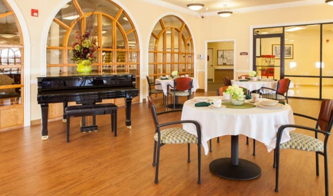 Dining area with a piano and floral arrangement