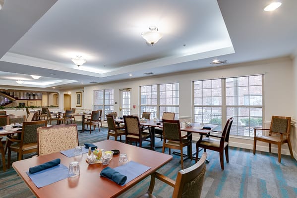 Dining room set up for a meal with tables and chairs