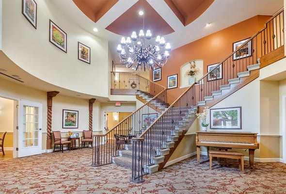 Bright lobby area with a staircase and piano