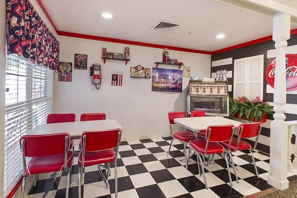 Interior view of a dining area with red chairs and checkered floor