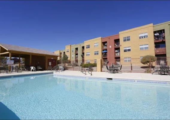 Outdoor pool area with chairs and facility in background