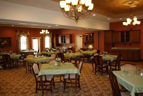 Cozy dining room with green tablecloths and floral centerpieces