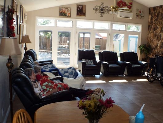 Residents enjoying a cozy lounge with recliners and natural light