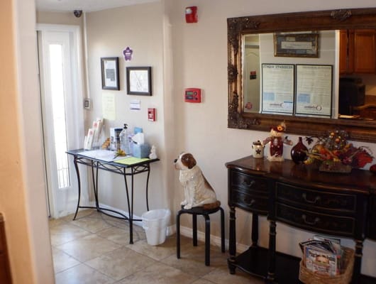 Welcoming lobby area with a table, decor, and a dog statue.