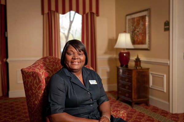 Staff member posing in a well-decorated interior space