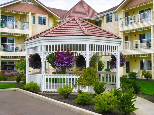 Outdoor gazebo surrounded by flowers and greenery