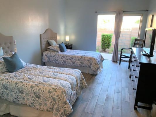Twin bedroom with floral bedding and natural light