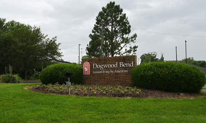 Sign for Dogwood Bend assisted living facility surrounded by greenery