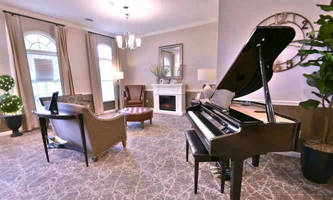 Modern living room featuring a grand piano and comfortable seating.