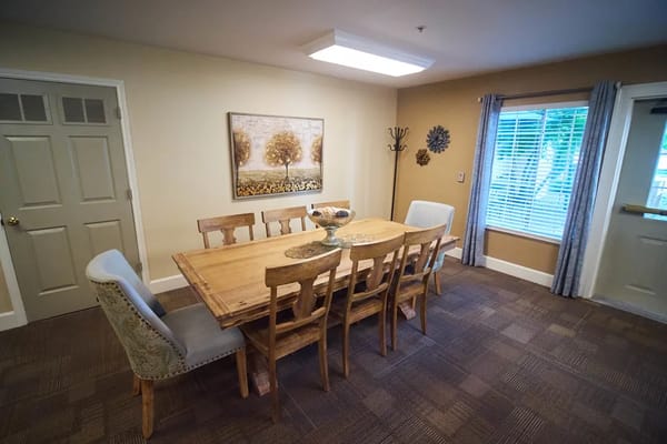 A dining room with a wooden table and chairs