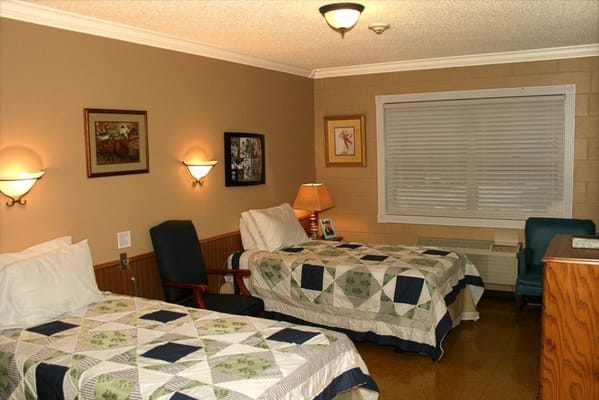 Bedroom with two twin beds and a chair in Fayetteville Manor