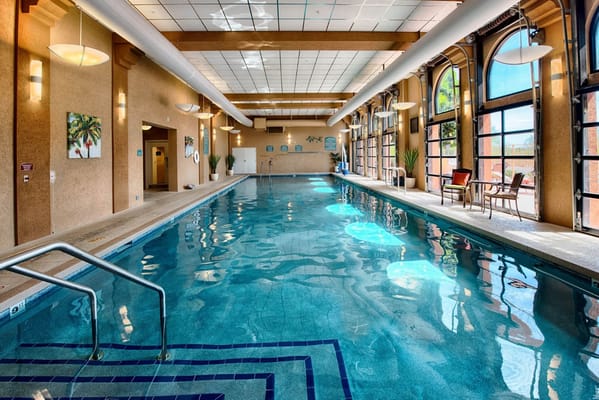 Indoor swimming pool with large windows and seating