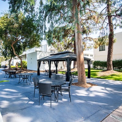 Outdoor seating area under a gazebo with tables in a courtyard
