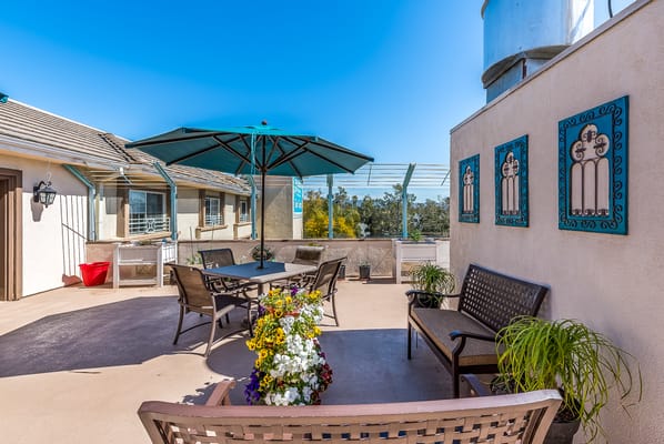 Outdoor seating area with flowers and an umbrella