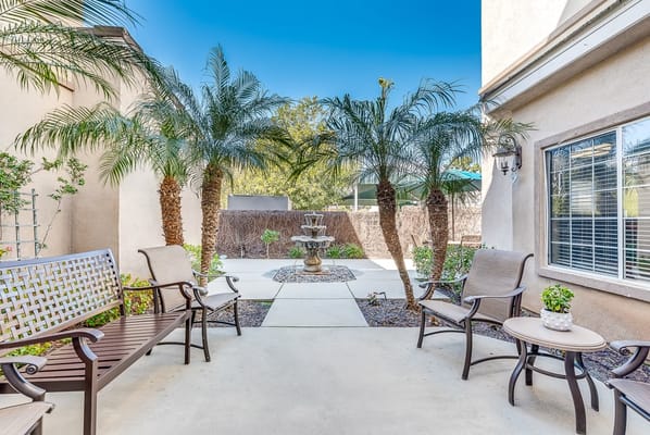 Outdoor seating area with palms and a fountain