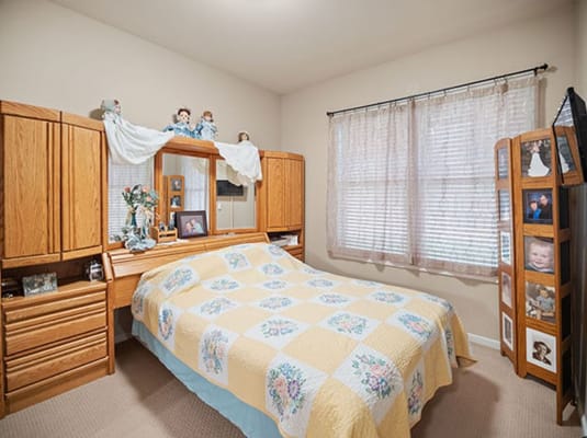 Cozy private bedroom with floral quilt and personal photos